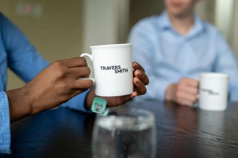 two people holding coffee cups 